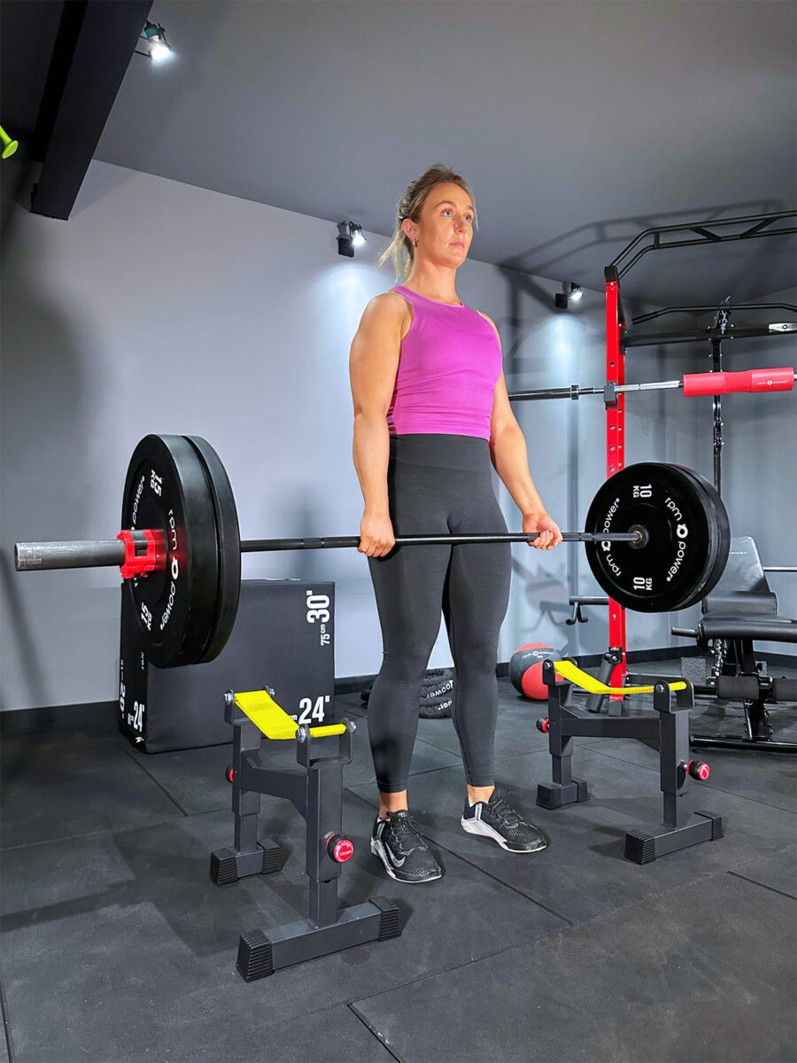 Woman holding Olympic Barbell and Weight Plates above Deadlift Barbell Drop Protector