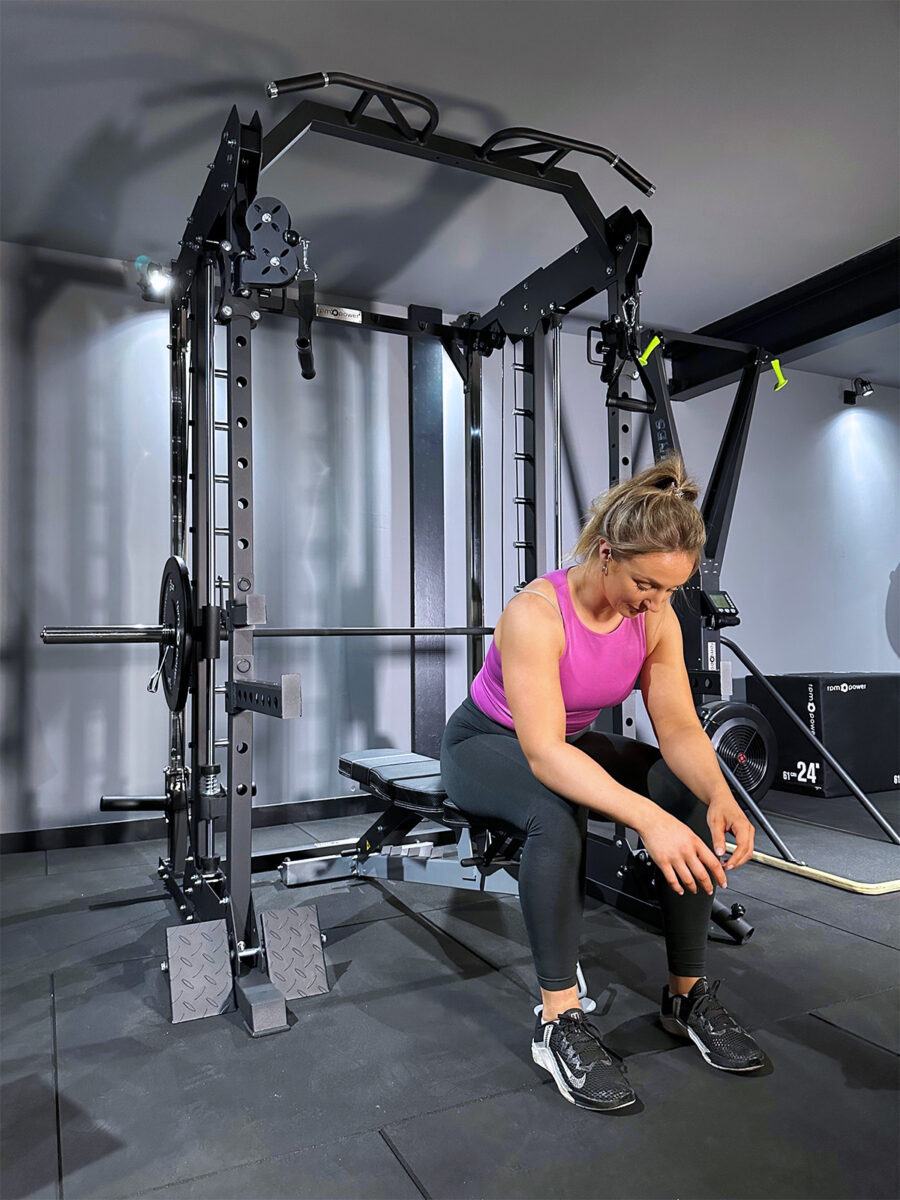 woman sitting on power rack home gym