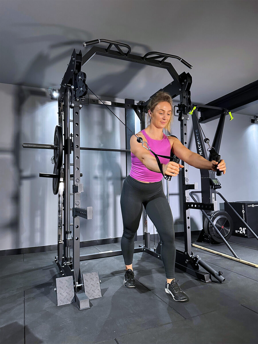 Woman doing cable rows on home gym squat rack