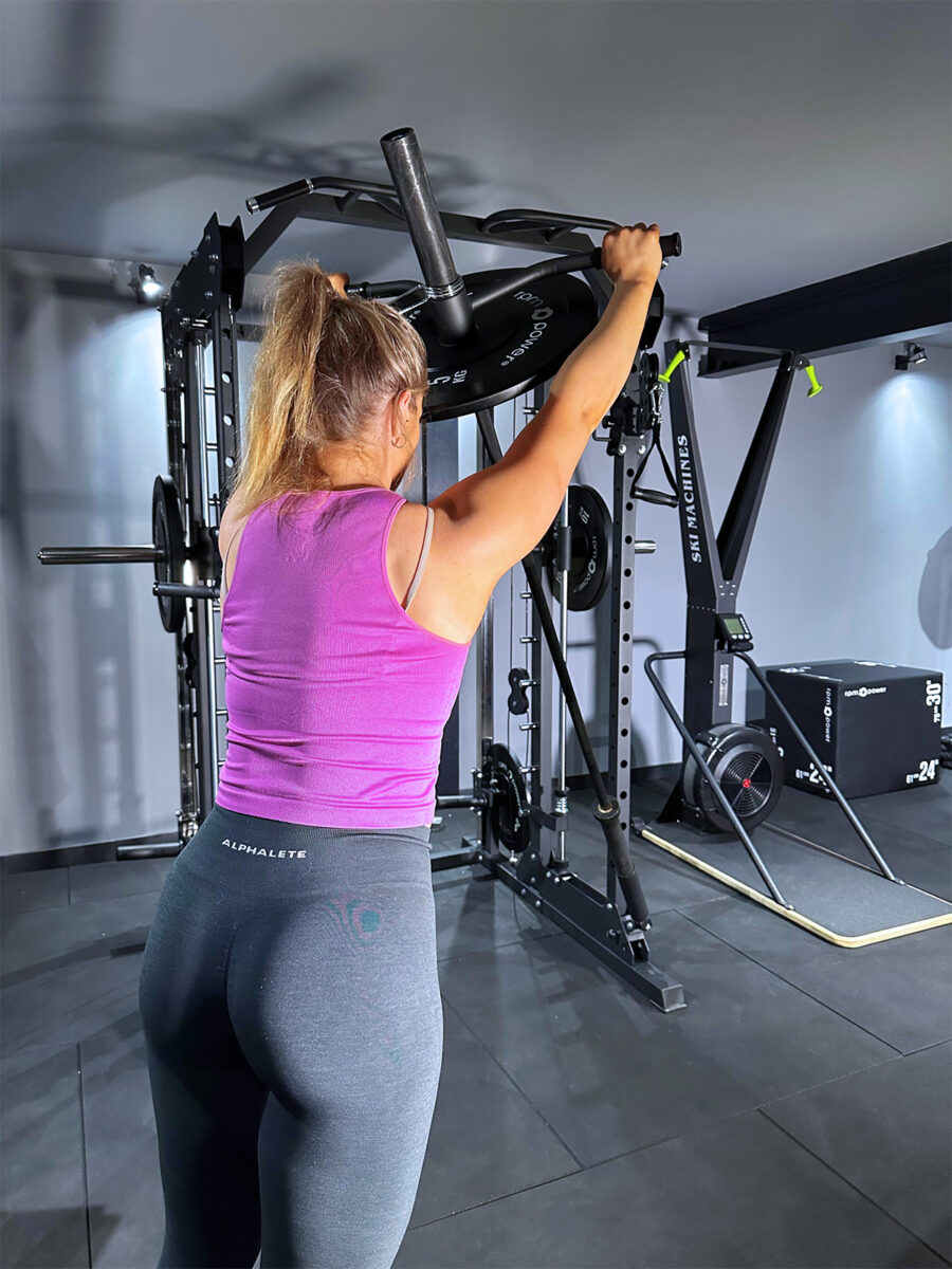 Woman using Landmine attachment on power squat rack