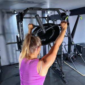 Woman using Landmine attachment on power squat rack