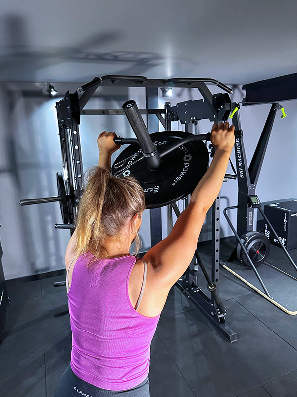 Woman using Landmine attachment on power squat rack