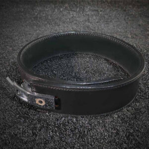 The black Powerlifting Belt Ultra closed on a black carpet surface.