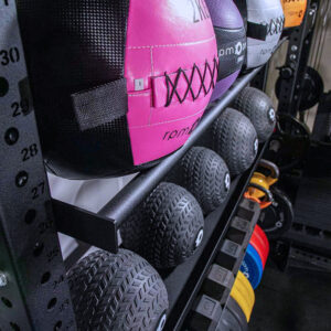 close up of wall balls and slam balls on squat rack