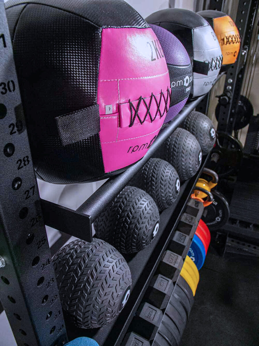 close up of wall balls and slam balls on squat rack