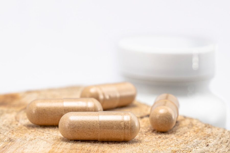 Four brown bodybuilding supplements on a wooden chopping board