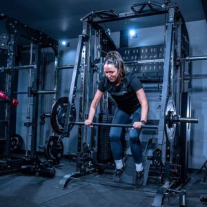 Woman using Multigym with Smith Bar, Weight Stack and Pull Up bar