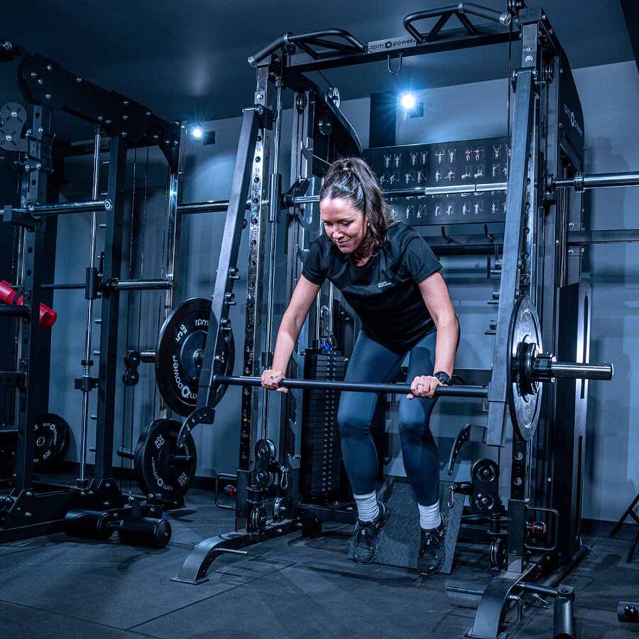 Woman using Multigym with Smith Bar, Weight Stack and Pull Up bar