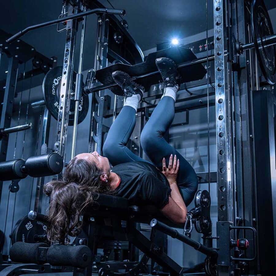 Woman using Multigym with Smith Bar, Weight Stack and Pull Up bar