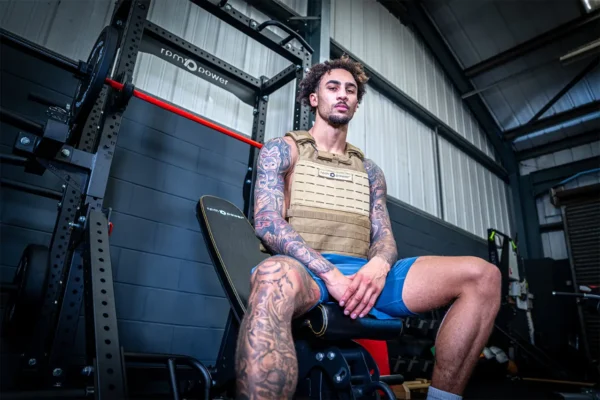 ben whittaker sitting on a weight bench in front of a half rack