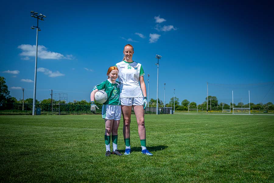 Aishling Moloney standing on a pitch with a child