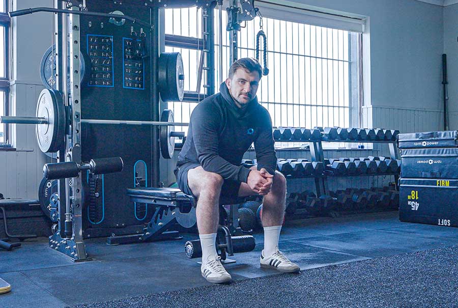 Diarmuid Barron sitting on a bench in a gym