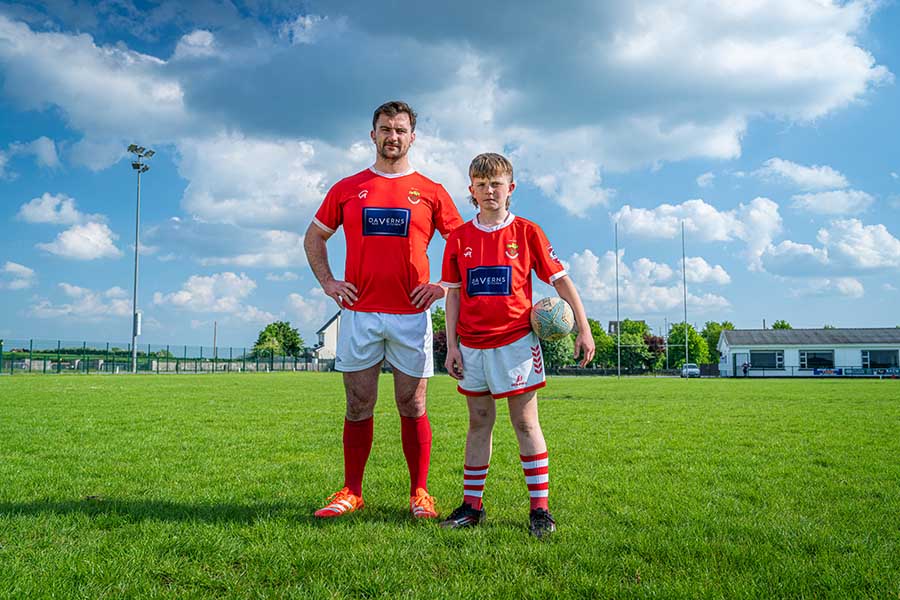 Diarmuid Barron standing on a pitch with a child