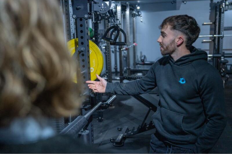 a man pointing to a multi-gym cable machine