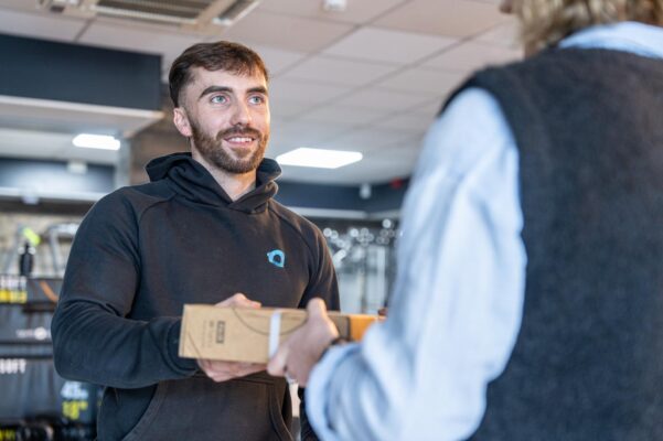 A man hands a product to a woman