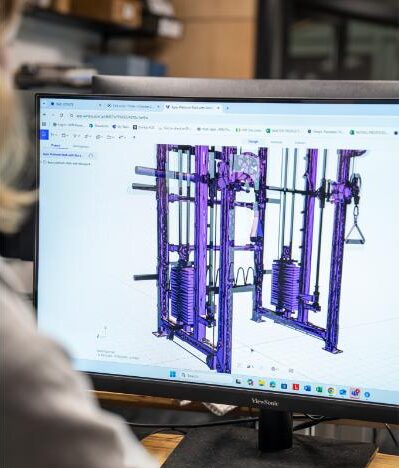 a person uses a computer to design fitness equipment