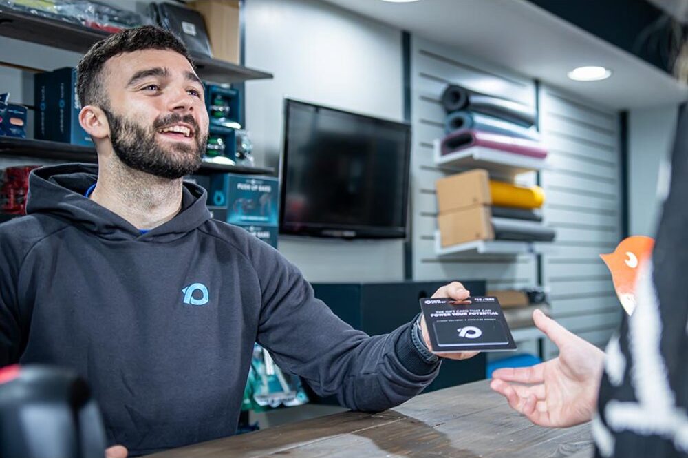 A man hands another person an RPM Power gift card