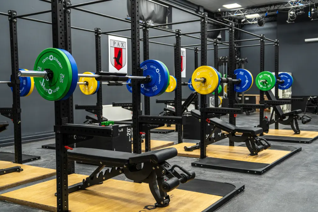 Glenstal Abbey school gym with rigs, weight benches, weight plates and deadlift platform and school crest