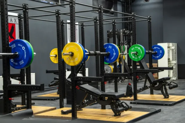 A gym set up with rigs, weight plates and barbells