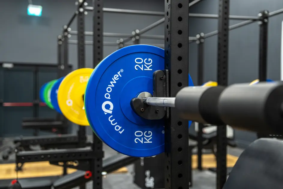 Close up of blue, yellow and green weight plates on a barbell