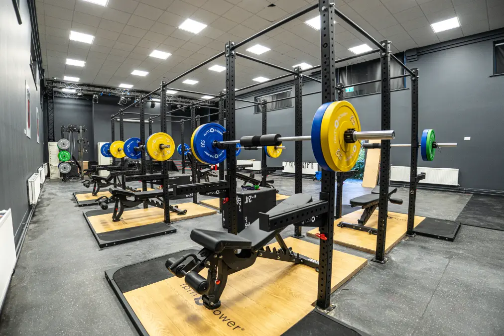 Glenstal Abbey school gym with rigs, weight benches, weight plates and deadlift platform