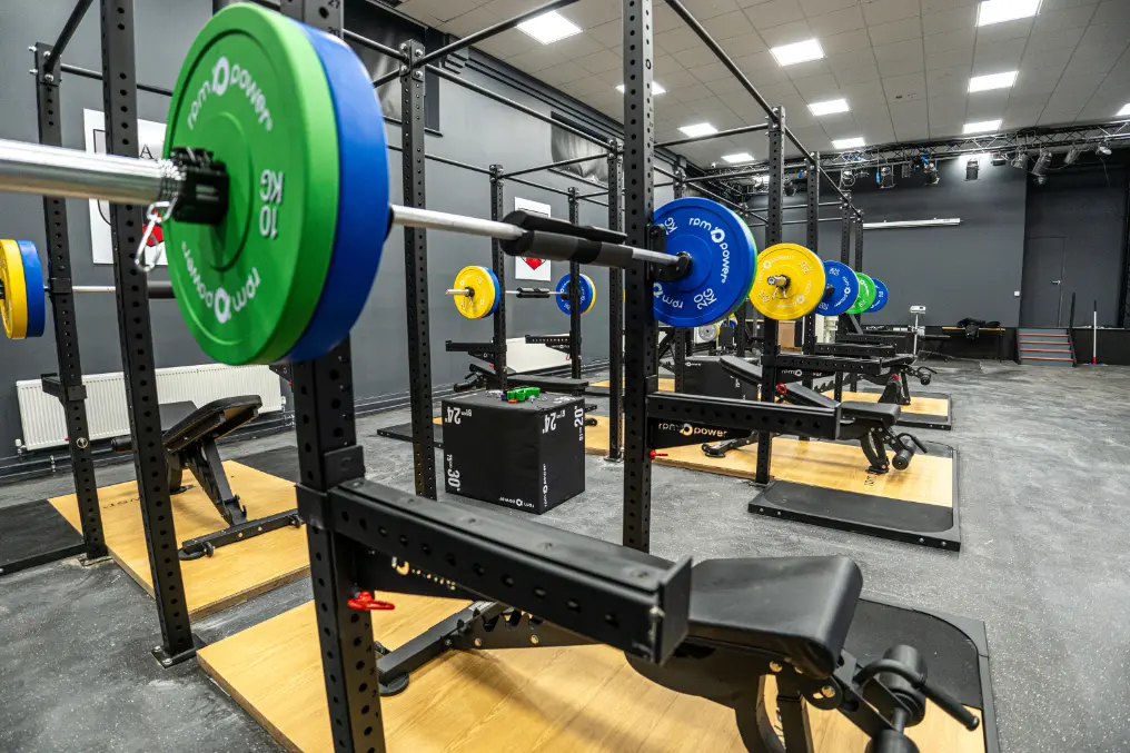 Weight plates on a barbell, weight bench and deadlift platform