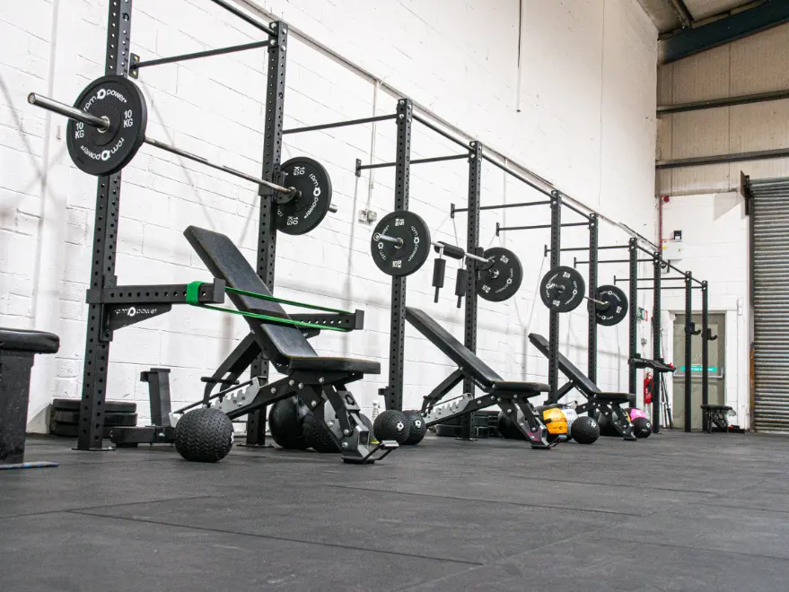 Wall-mounted bay rigs and weight benches in a gym