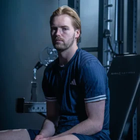 Kelleher sitting on a weight bench
