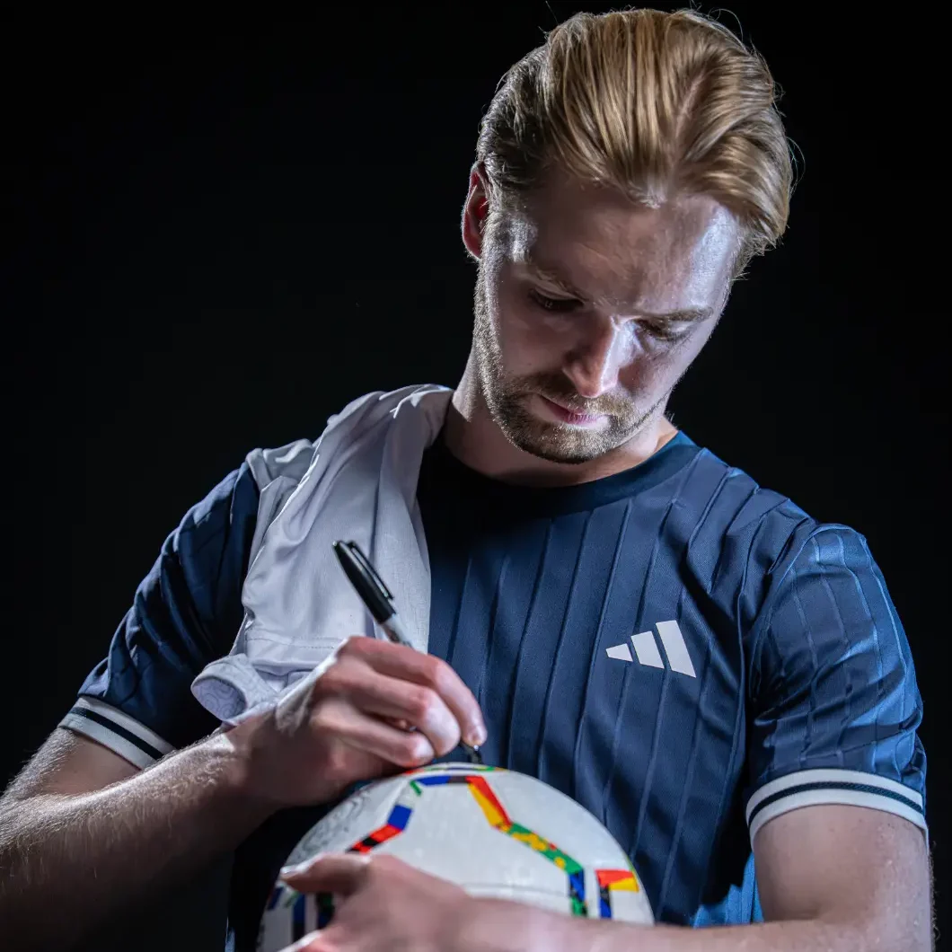 Caoimhin Kelleher signing a football